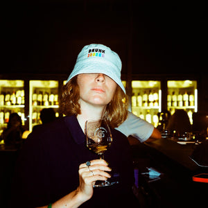 Drunk and queer bucket hat in a natural wine spot
